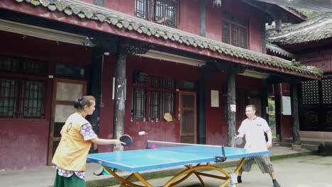 Chengdu,-China---July-2019-:-Man-and-woman-playing-ping-pong-in-the-courtyard-of-Wenshu-Monastery-in-Chengdu,-Sichuan-Province