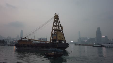 Lento-Pan-Sampan-Pasando-Buque-Portacontenedores-En-El-Puerto-De-Victoria,-Hong-Kong