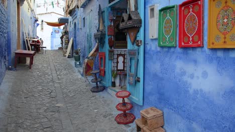 Chefchaouen-Traditionelle-Blaue-Straße-Mit-Lokalem-Geschäft,-Das-Populäre-Kunst-Ausstellt