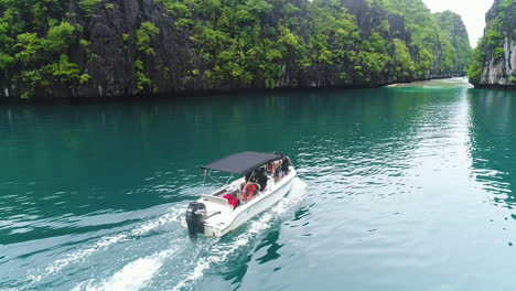 Toma-Aérea-En-Cámara-Lenta-De-Un-Crucero-De-Lanchas-Rápidas-En-Una-Laguna-Azul-Clara-En-Palawan-Filipinas