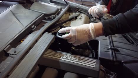 White-male-remove-cap-from-power-steering-pump,-static