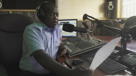Radion-sprecher-Liest-Nachrichten-Von-Einem-Blatt-Papier-über-Einen-Lokalen-Radiosender-In-Uganda