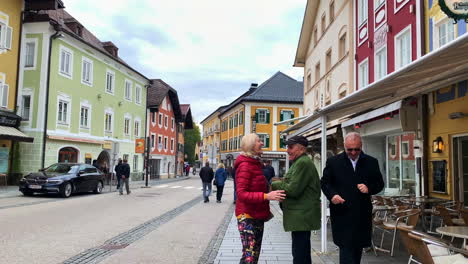 A-town-of-Mondsee-in-Salzburg-with-people-walking-and-colourful-building-on-side-road