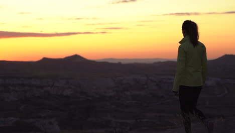 Fiery-sky-just-after-sunset-in-Goreme-Turkey-with-a-woman-tourist-slowly-into-frame-in-slow-motion