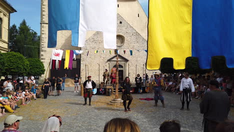 Gente-Viendo-Una-Recreación-Medieval-De-Caballeros-Y-Nobles-Discutiendo-En-La-Plaza-Principal,-Festival-Preludij-En-Slovenj-Gradec-Eslovenia