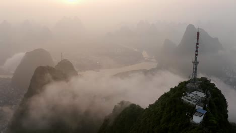 Yangshuo-Berge-4K-Drohne,-Die-Um-Den-Fernsehturm-über-Den-Nebligen-Sonnenaufgangswolken-Kreist
