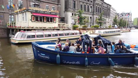 Blick-Auf-Touristische-Kanalvergnügungsboote,-Die-Durch-Brücken-In-Amsterdam,-Holland,-Niederlande,-Europa-Drehen