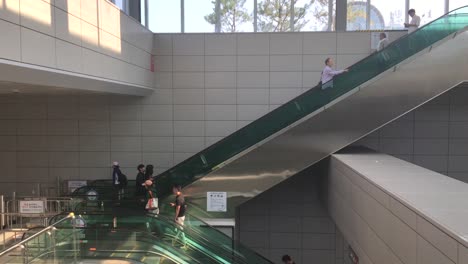 Subway-passengers-ride-an-escalator-at-Olympic-Park-station,-Oryung-dong,-Songpa-gu,-Seoul,-South-Korea