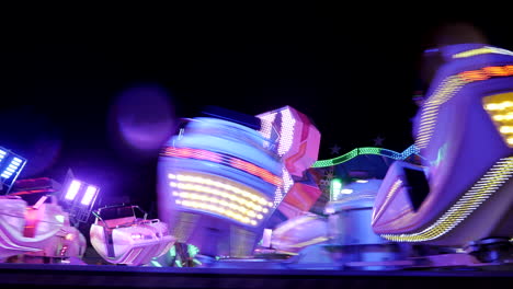 Crazy-fast-spinning-illuminated-carousel,outdoor-at-night-in-fun-fair-park,close-up