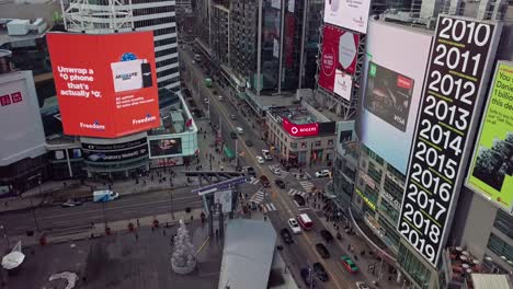 Aerial-Reveal-of-Downtown-City-Shops-and-Big-Ad-Screen,-Wide-Dolly-Out