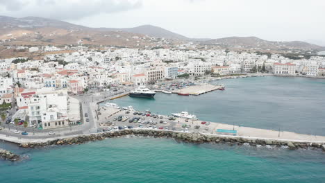 Drone-aerial-view-of-port-of-Tinos-in-Greece-flying-backwards