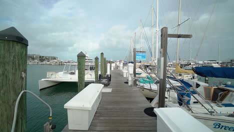 Tracking-Shot-Down-Dock-With-Sailboats-on-a-Cloudy-Day