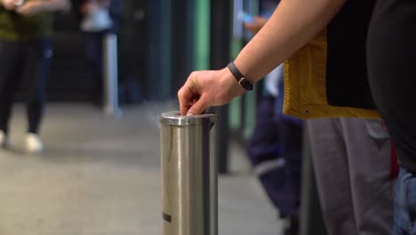 Person-puts-cigarette-in-metal-ashtray-at-airport-and-walks-away