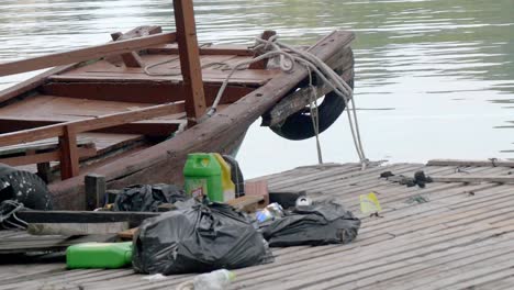 Ha-Long-Bay,-Vietnam---Ein-Altes-Holzboot,-Das-Von-Einer-Holzplattform-Mit-Angelausrüstung-An-Der-Spitze-Angedockt-Ist