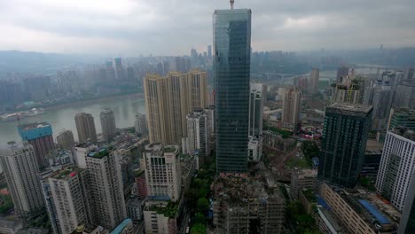 Daytime-time-lapse-of-skyscraper-building-under-construction-near-Yangtze-River,-Locked-speed-up-establishing-shot