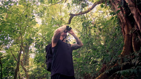Junger-Touristischer-Mann,-Der-Wilde-Tiere-Durch-Ein-Fernglas-Mitten-Im-Dschungel-In-Costa-Rica-Beobachtet
