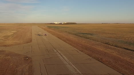 Ein-Airshow-Doppeldecker-Pitts-S2B,-Der-Die-Landebahn-Hinunterfliegt,-Hebt-Bei-Sonnenaufgang-Von-Einem-Kleinen-Flughafen-Ab