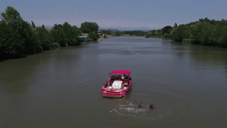 Wasserskifahrer-Springt-Von-Der-Rückseite-Des-Schnellboots-Ins-Wasser-Und-Bereitet-Sich-Darauf-Vor,-Im-See-Ski-Zu-Fahren