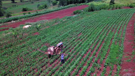 Man-preparing-tractor-for-spraying-cornfield,-rural-area,-countryside