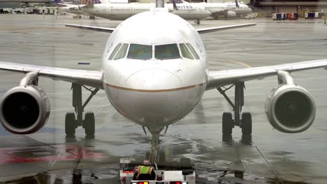 Vista-Frontal-De-Cerca-De-Un-Jet-Boeing-Que-Es-Empujado-Hacia-Atrás-Desde-Una-Puerta-En-El-Aeropuerto-De-San-Francisco-En-Una-Tarde-Lluviosa