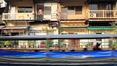 Saen-Saep-Canal-In-Bangkok,-Thailand---Khlong-Saen-Saep-Boat-Service-Passes-By-In-Front-Of-Two-Storey-Houses---Close-up-Shot
