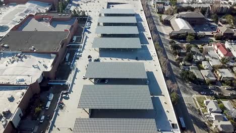 Implementación-De-Energía-Solar-En-Uso-Comercial,-Vista-Aérea-De-Módulos-De-Paneles-Fotovoltaicos-En-Estacionamiento-De-Centro-Comercial,-Glendale-California-Usa