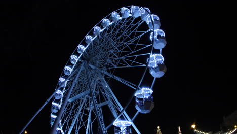 Una-Toma-Nocturna-De-Una-Gran-Rueda-De-Hierro-Iluminada-Con-Un-Diseño-De-Cabina-Que-Domina-Los-Mercados-Navideños-En-El-Centro-De-Brno-Capturada-A-Cámara-Lenta-De-4k-60fps