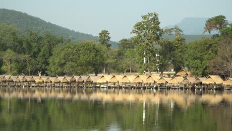 Beautiful-Huay-Tung-Tao-Lake-in-Chiang-Mai-with-a-lush-mountain-backdrop,-displaying-the-straw-huts-on-the-lake-front