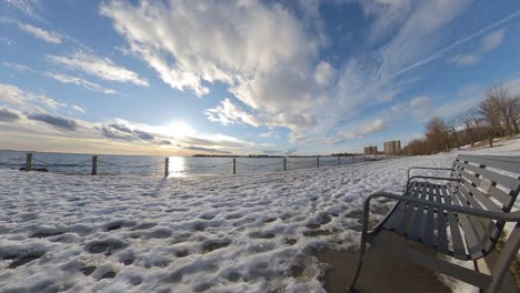 Winter-timelapse-during-sunset-near-waterfront-low-angle-with-snow