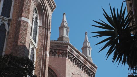 Basílica-De-Santa-Maria-Gloriosa-Dei-Frari,-Iglesia-Antigua-En-Venecia,-Norte-De-Italia,-Tiro-De-ángulo-Bajo-De-Las-Torres