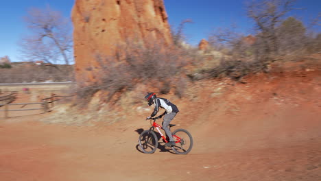 Joven-Saltando-Rampas-De-Tierra-En-Una-Carrera-De-Obstáculos,-Con-Una-Bicicleta-De-Montaña,-En-Colorado-Springs,-Colorado