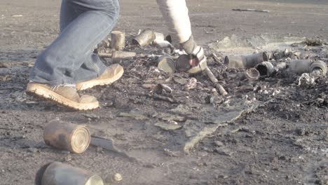 Picking-up-aluminium-tin-cans-discarded-on-the-ground-after-a-fire