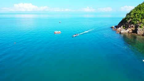 Boats-with-tourists-on-board-sailing-on-blue-turquoise-sea-around-beautiful-coastline-of-tropical-island-on-a-summer-sunny-day-in-Thailand