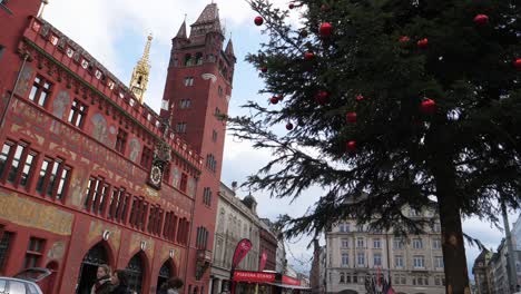 Tiro-Medio,-árbol-De-Navidad-Con-Adorno-De-Bola-Roja,-Ayuntamiento-De-Basilea-En-El-Fondo