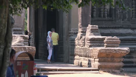 Mittlere-Außenaufnahme-Von-Touristen,-Die-Den-Antiken-Tempel-Durch-Die-Tür-Gehen