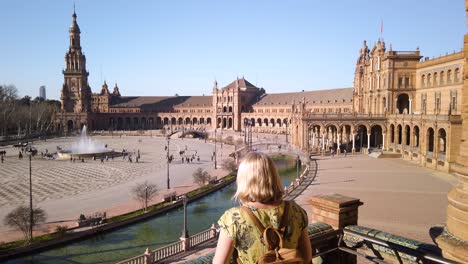 Blonde-woman-on-balcony-overlooking-Plaza-de-Espana,-Seville,-Spain,-PAN-RIGHT