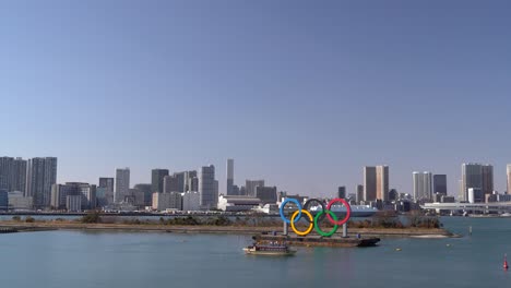 A-ferry-boat-crossing-the-Tokyo-Bay-where-the-Olympic-Sign-is-situated---wide-shot