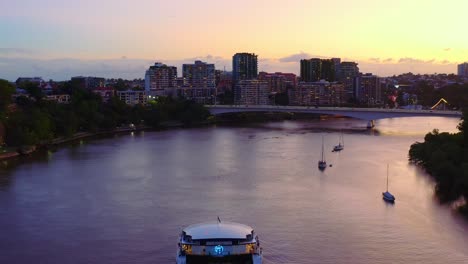 Deluxe-Super-Yacht-Segeln-Auf-Ruhigem-Ozeanwasser-Mit-Stadtbild-Im-Hintergrund-Während-Des-Sonnenuntergangs-In-Marina-Mirage,-Goldcoast-Australien