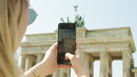 Woman-Taking-Pictures-with-Mobile-Phone-of-Brandenburg-Gate-in-Berlin