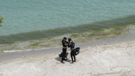 Top-View-on-Male-Scuba-Diver-Helping-His-Partner-Putting-on-Head-Cover-Nearby-Black-Sea