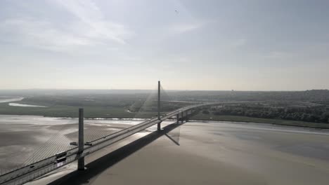 Landmark-Mersey-Gateway-bridge-traffic-crossing-river-Mersey-aerial-view-skyline-high-pan-left