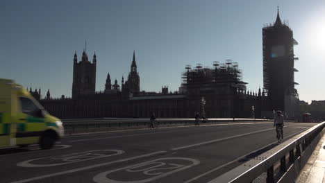 An-ambulance-drives-over-an-almost-deserted-Westminster-Bridge-past-the-Houses-of-Parliament-on-a-warm-and-sunny-Spring-evening-during-the-Coronavirus-outbreak