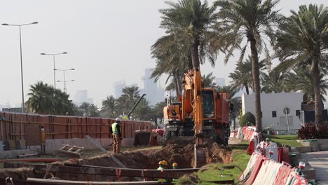 Ein-Kran,-Der-Während-Des-Autobahnbaus-Den-Boden-Gräbt-Und-Erde-Auf-Einem-Muldenkipper-Sammelt---Doha,-Katar--03-10-2020