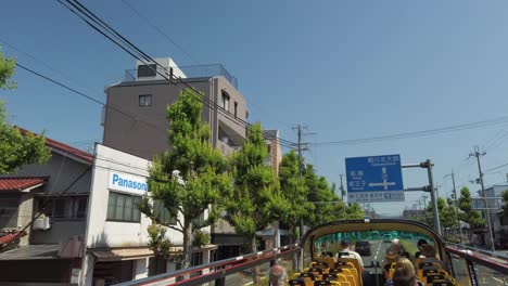 Touristic-hop-on-hop-off-bus-tour-with-open-double-decker-through-the-Japanese-city-of-Kyoto