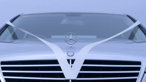 Nahaufnahme-Einer-Mercedes-Benz-Kühlerfigur-Mit-Hochzeitsdekorationen