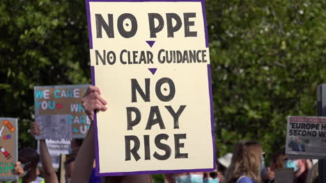 A-homemade-placard-that-says-“No-PPE,-no-clear-guidance,-no-pay-rise”-is-held-up-on-the-Pay-Justice-National-Health-Service-worker-protest