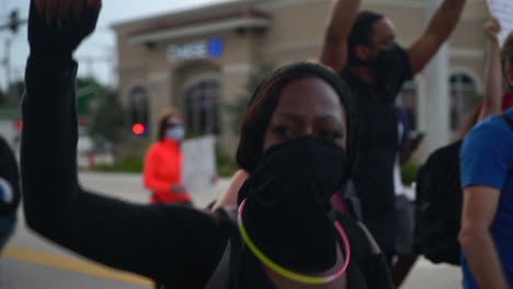 Black-woman-protesting-with-raised-fist-at-Black-Lives-Matter-protest,-medium-shot