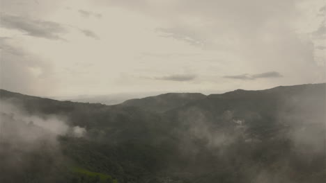 Flight-drone-trough-clouds-above-mountains-in-cloudy-weather