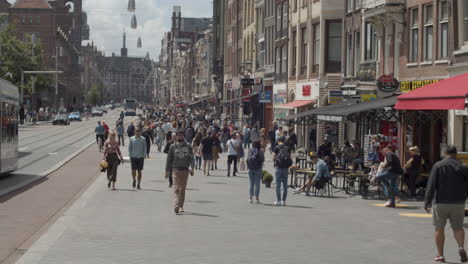 People-walking-over-busy-main-street-in-Amsterdam-city-centre---close