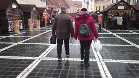 Brasov,-Romania---7-December-2019-:-People-walking-on-the-Old-Square-on-day-time,-Christmas-Fair-in-Brasov-,-Winter-Season,-Christmas-decorations